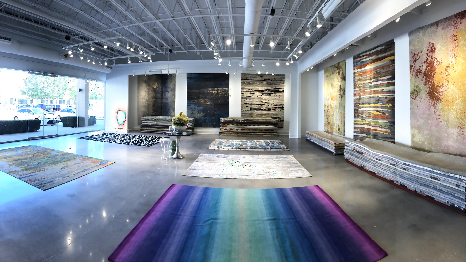 Arsin Rug Gallery showroom with large rugs displayed across the gallery floor and walls